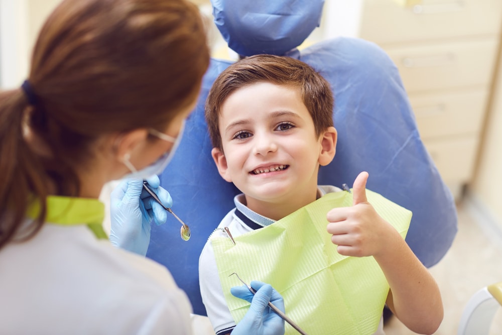 kid.smiling.dental chair